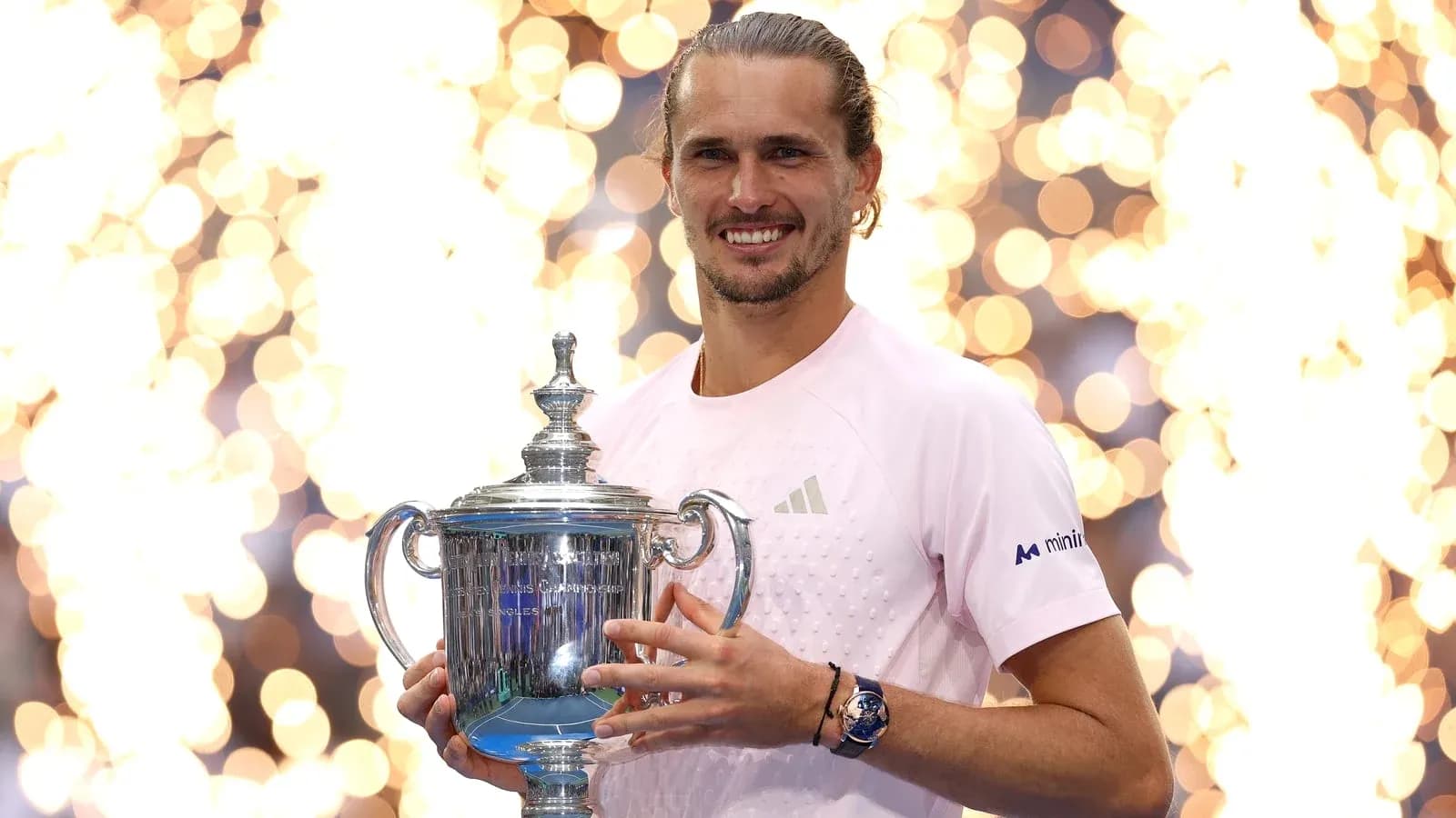 Player holding US Open trophy with fireworks backdrop Player holding US Open trophy with fireworks backdrop