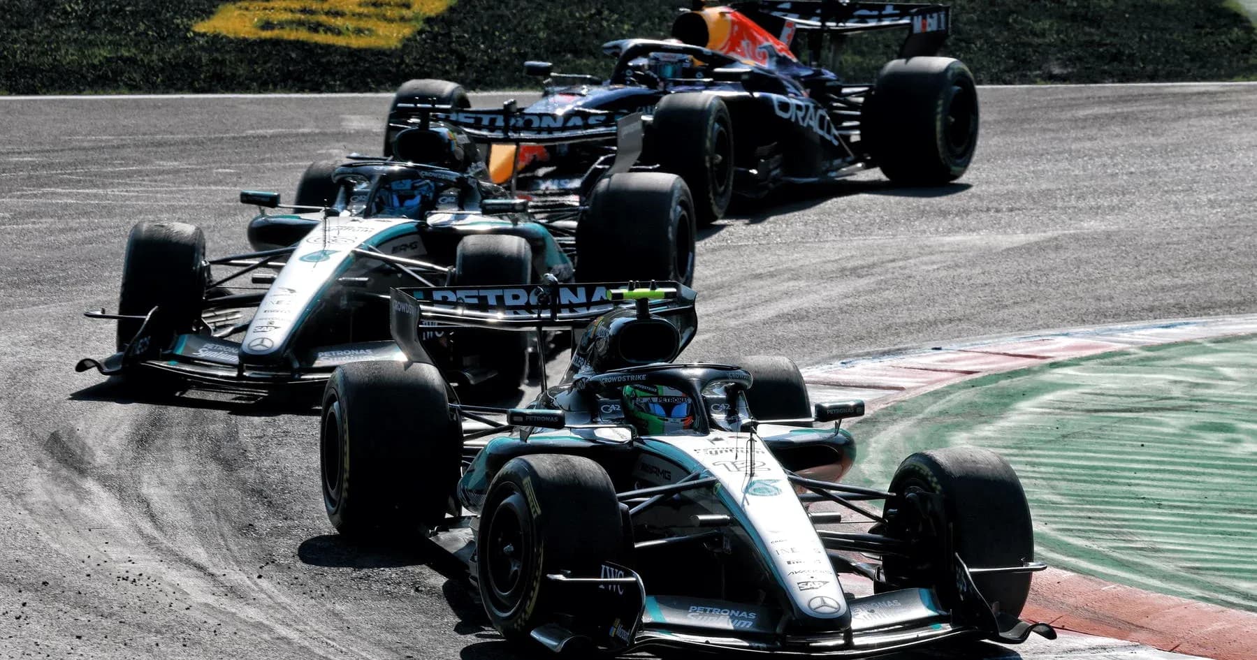 Three Formula 1 cars racing on a track Three Formula 1 cars racing on a track