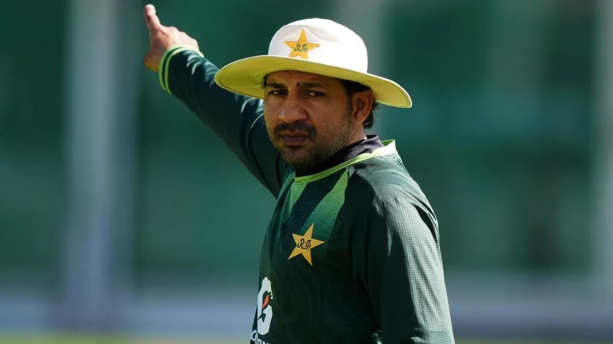 Cricketer signaling during training session in uniform Cricketer signaling during training session in uniform