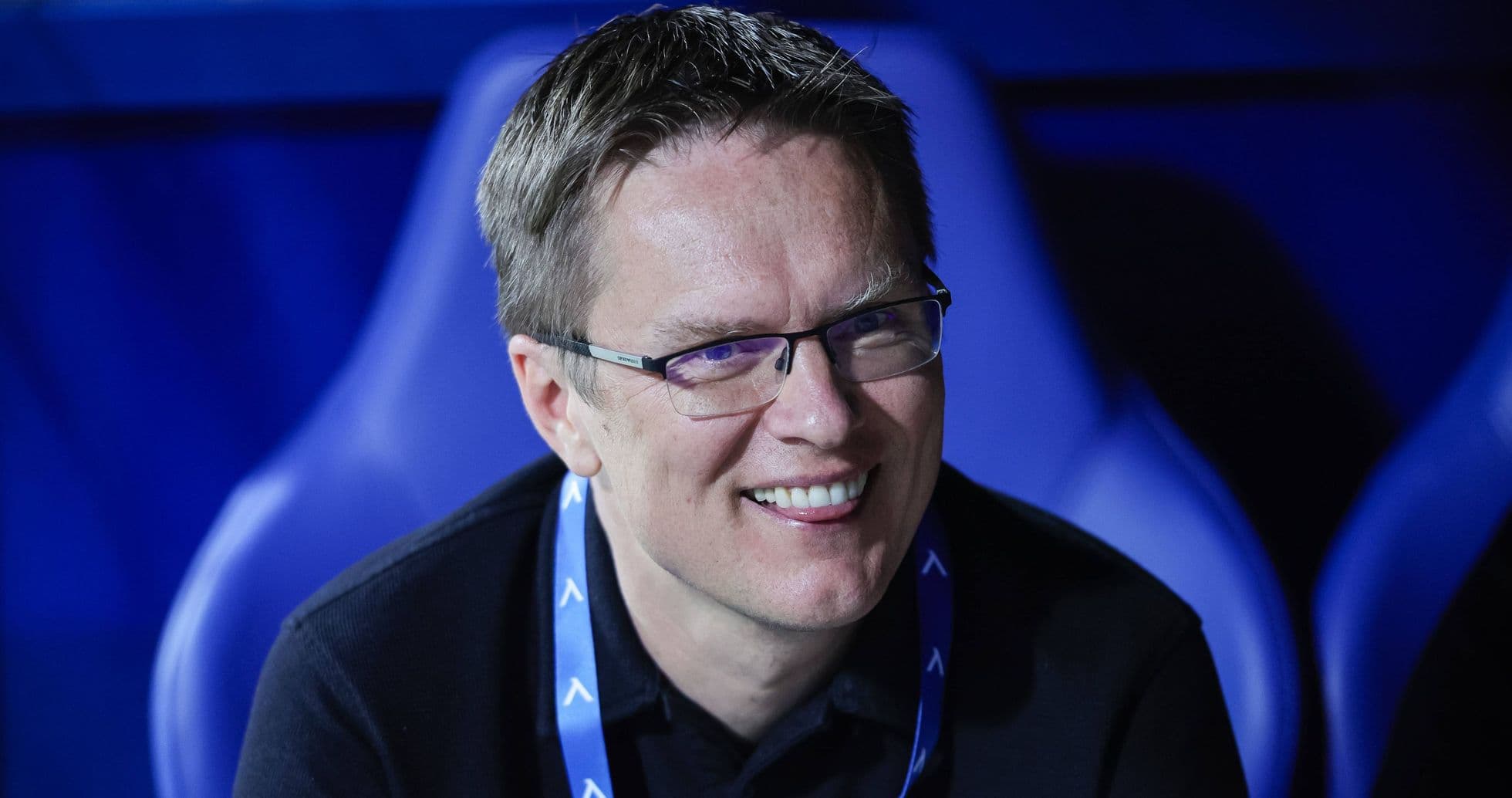Man smiling while seated in sports venue Man smiling while seated in sports venue
