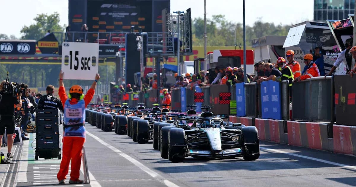 Race cars lined up in pit lane with time penalty sign Race cars lined up in pit lane with time penalty sign