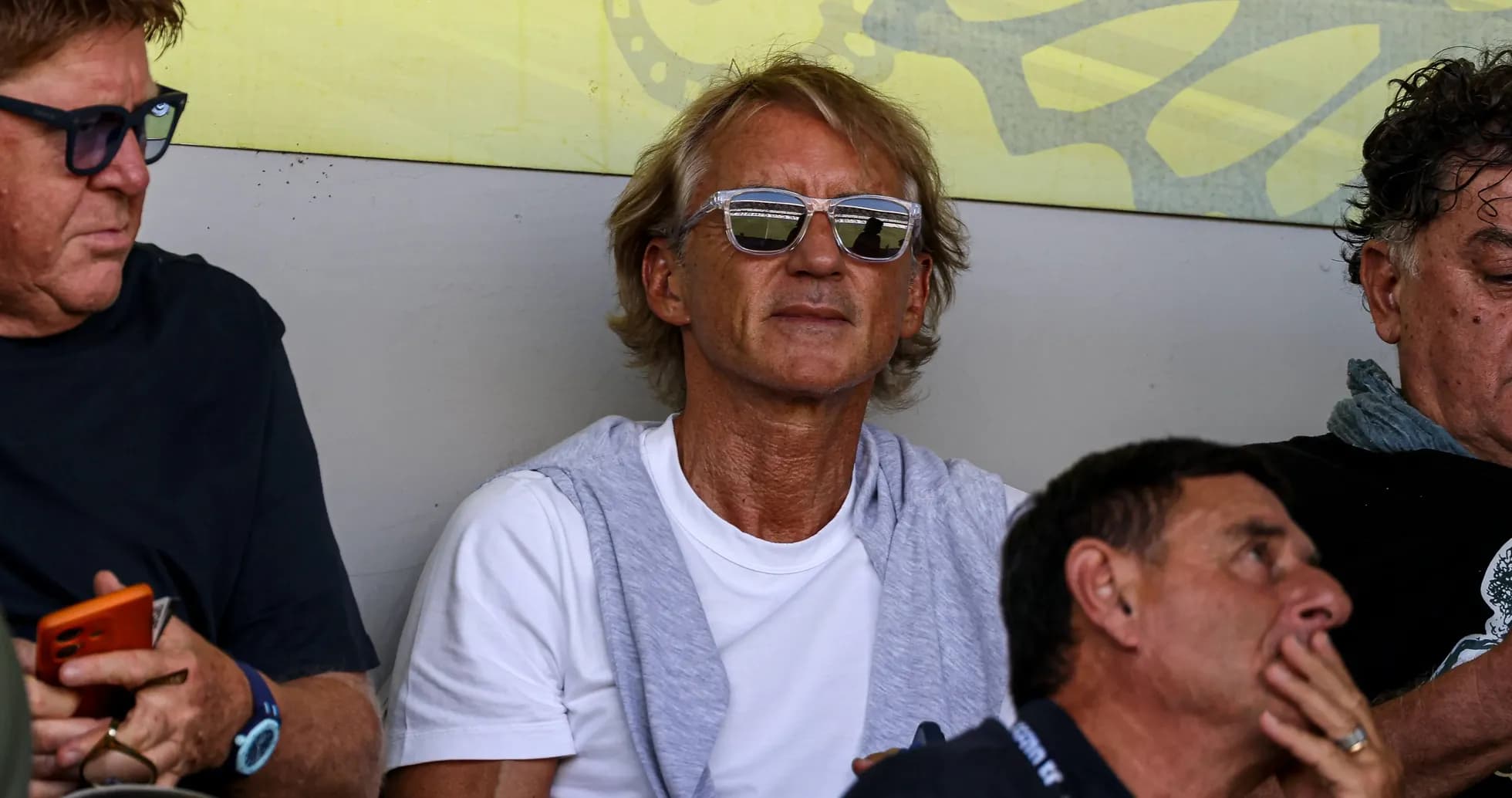 Man with sunglasses sitting in spectator area Man with sunglasses sitting in spectator area