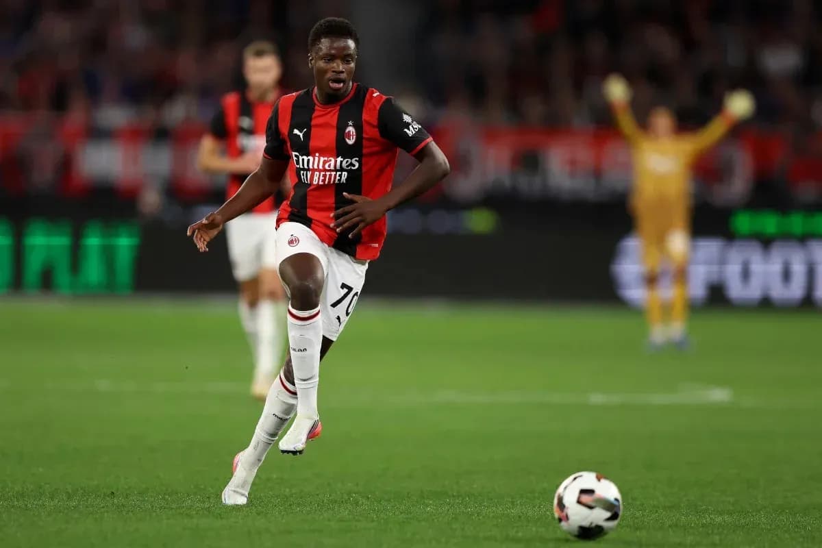 Player in AC Milan kit sprinting towards the ball Player in AC Milan kit sprinting towards the ball