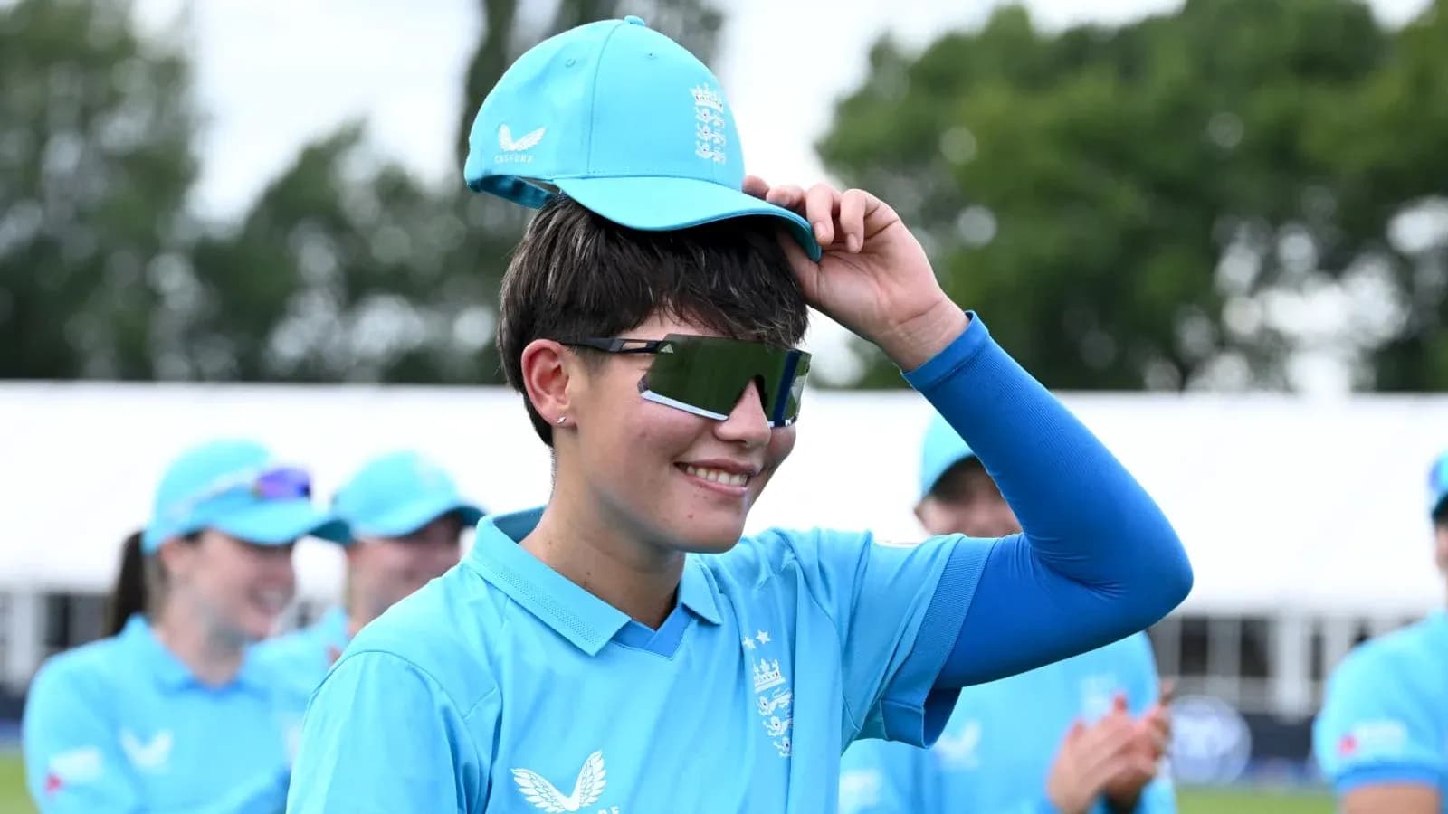 Player adjusting cap during team event in blue uniform Player adjusting cap during team event in blue uniform