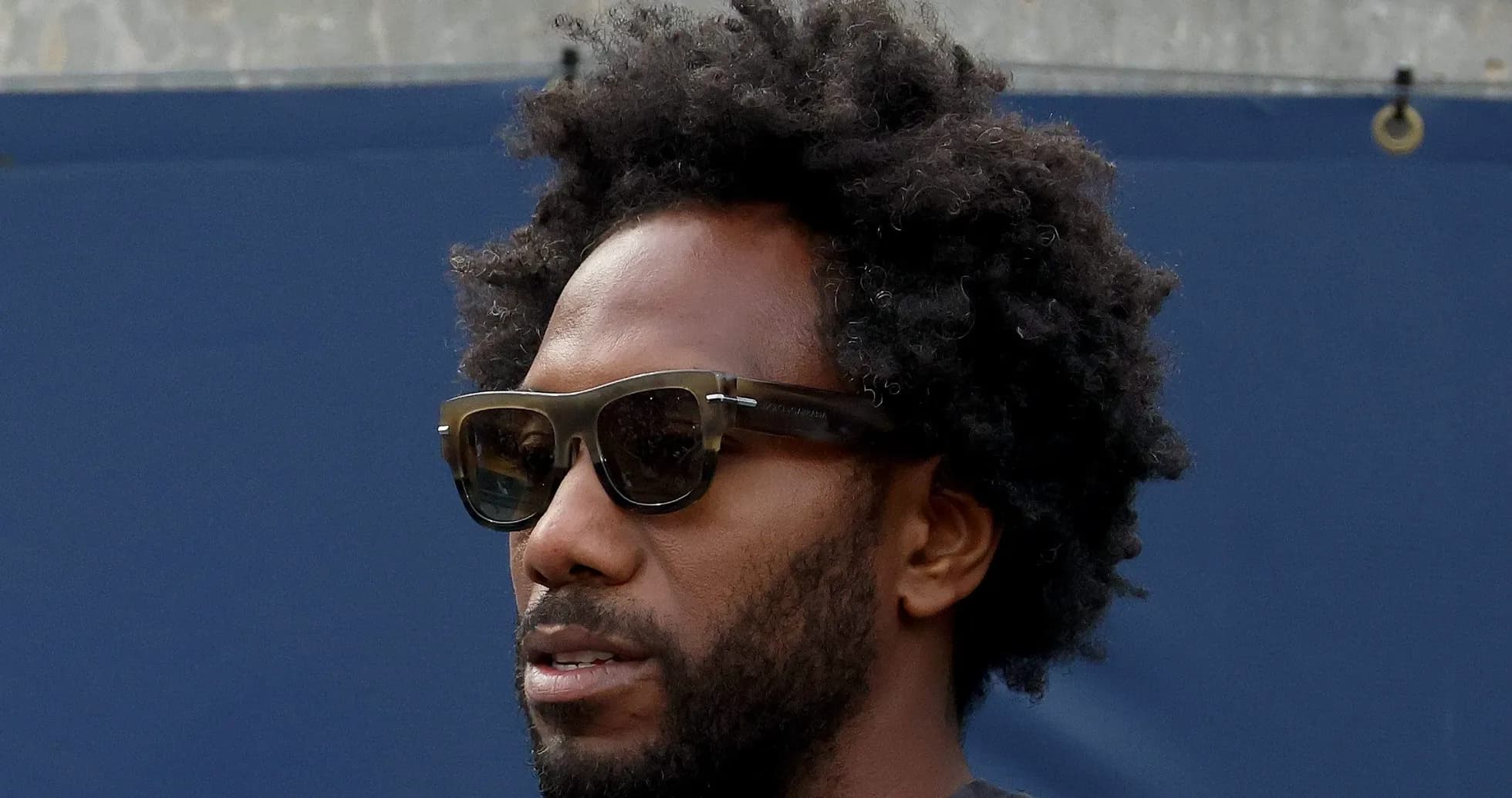 Person wearing sunglasses with curly hair Person wearing sunglasses with curly hair