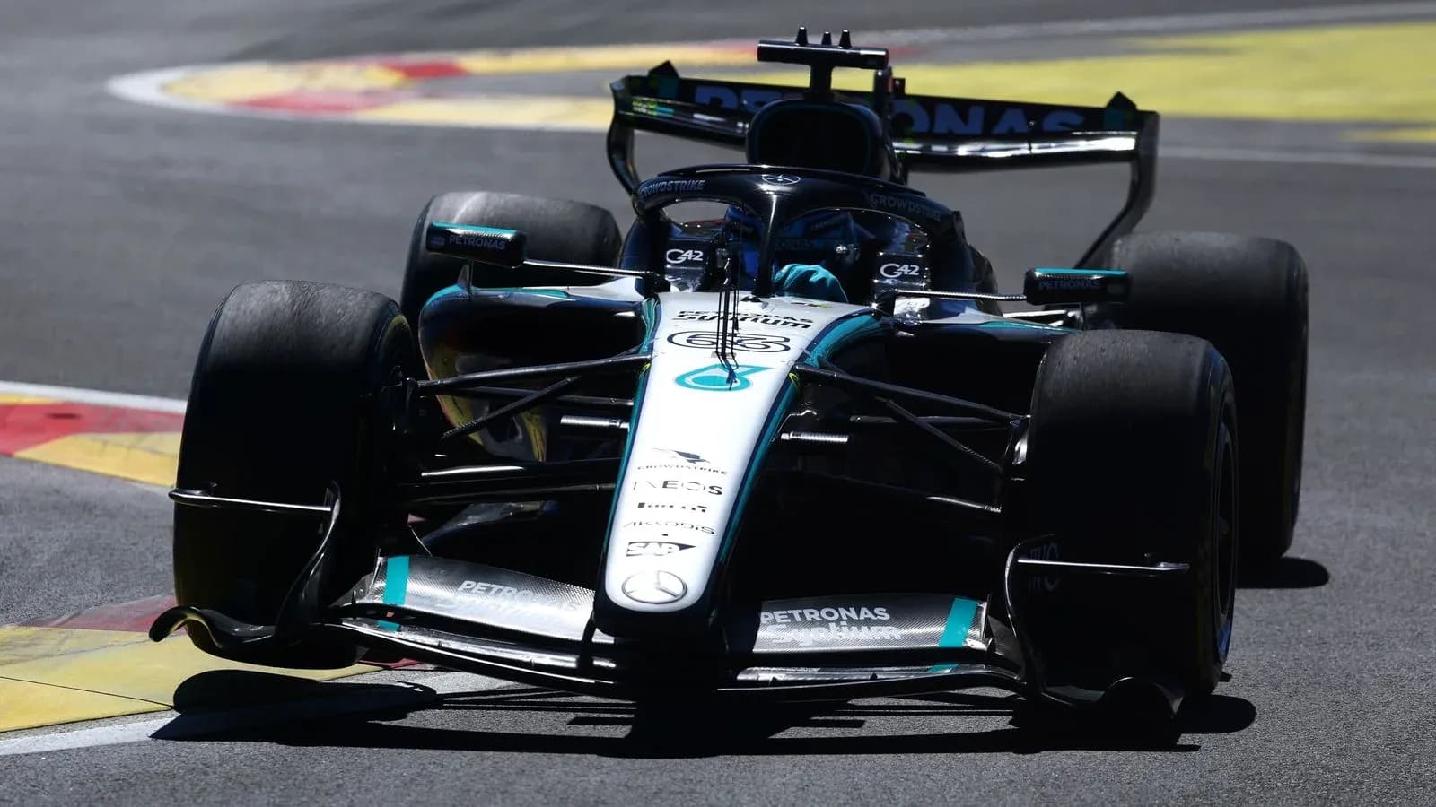 Mercedes Formula 1 car navigating a corner on track Mercedes Formula 1 car navigating a corner on track