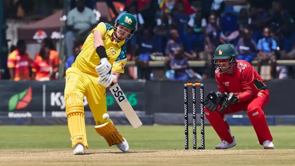 Batsman hitting the ball while wicketkeeper crouches Batsman hitting the ball while wicketkeeper crouches