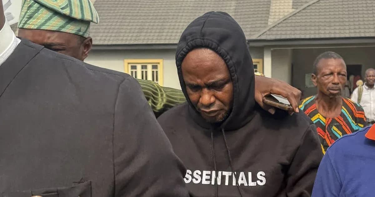 Man in hoodie being escorted by others outdoors Man in hoodie being escorted by others outdoors