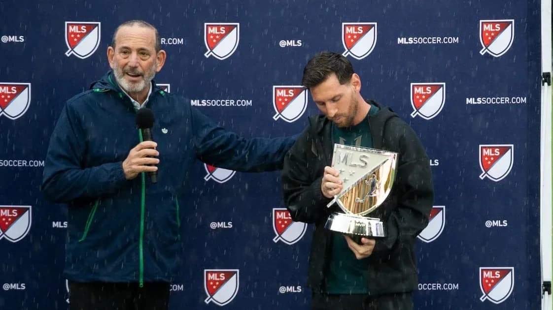 MLS commissioner presenting trophy to player in rain MLS commissioner presenting trophy to player in rain