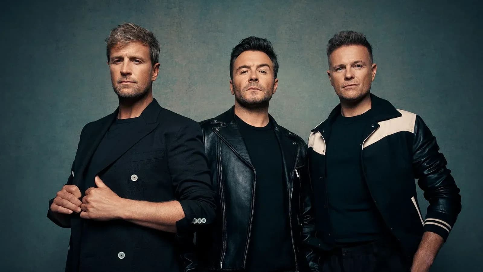 Three men posing against a textured background Three men posing against a textured background