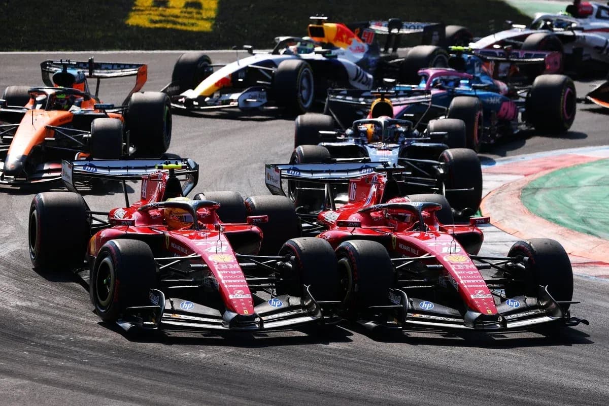 Two Ferrari cars racing closely during Formula 1 event Two Ferrari cars racing closely during Formula 1 event