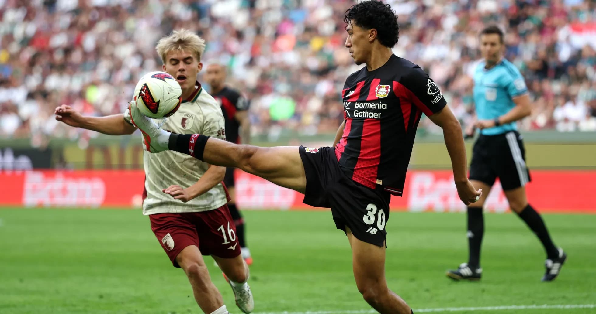 Player kicking ball while opponent attempts to intercept Player kicking ball while opponent attempts to intercept