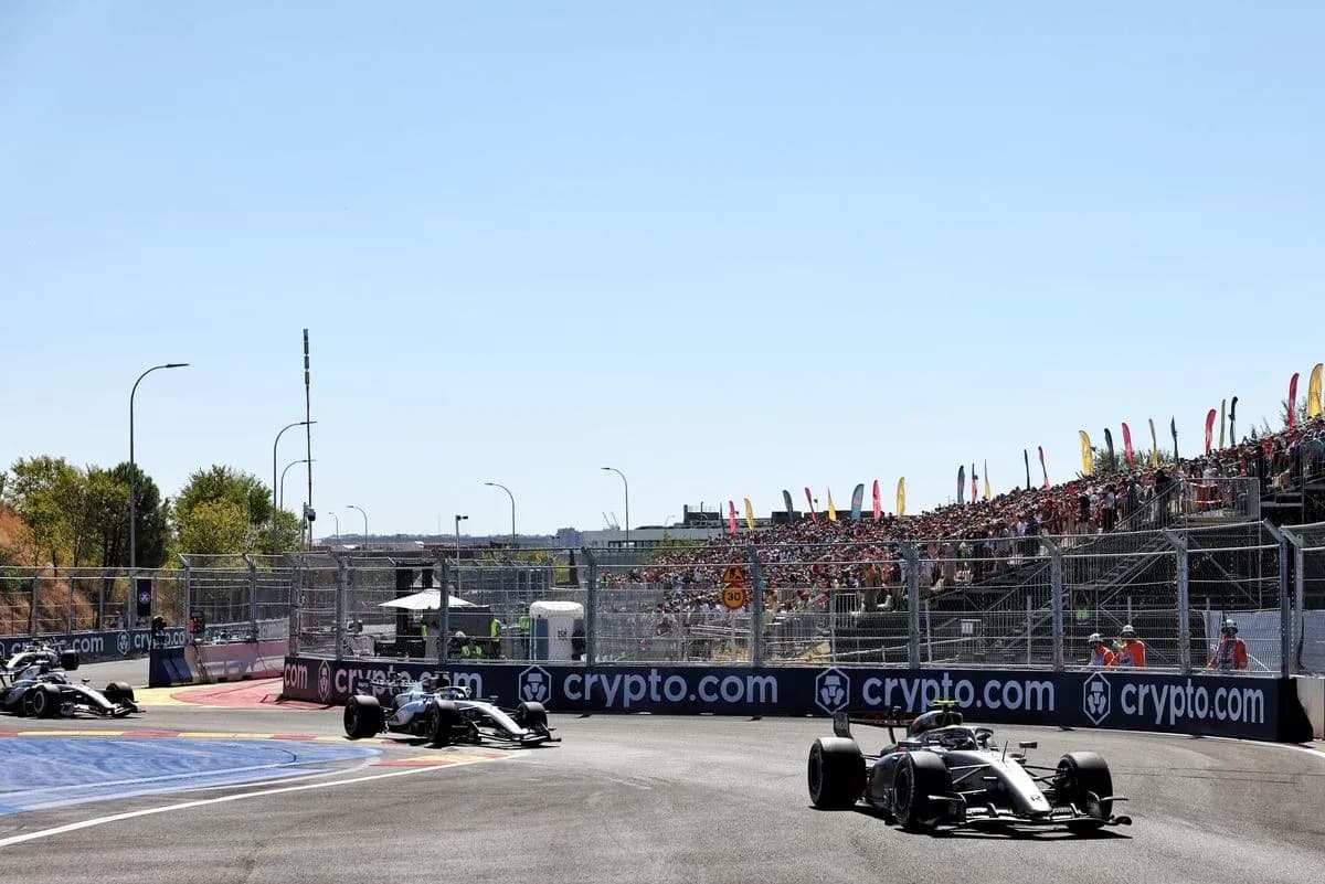 Two Formula 1 cars racing at a circuit Two Formula 1 cars racing at a circuit