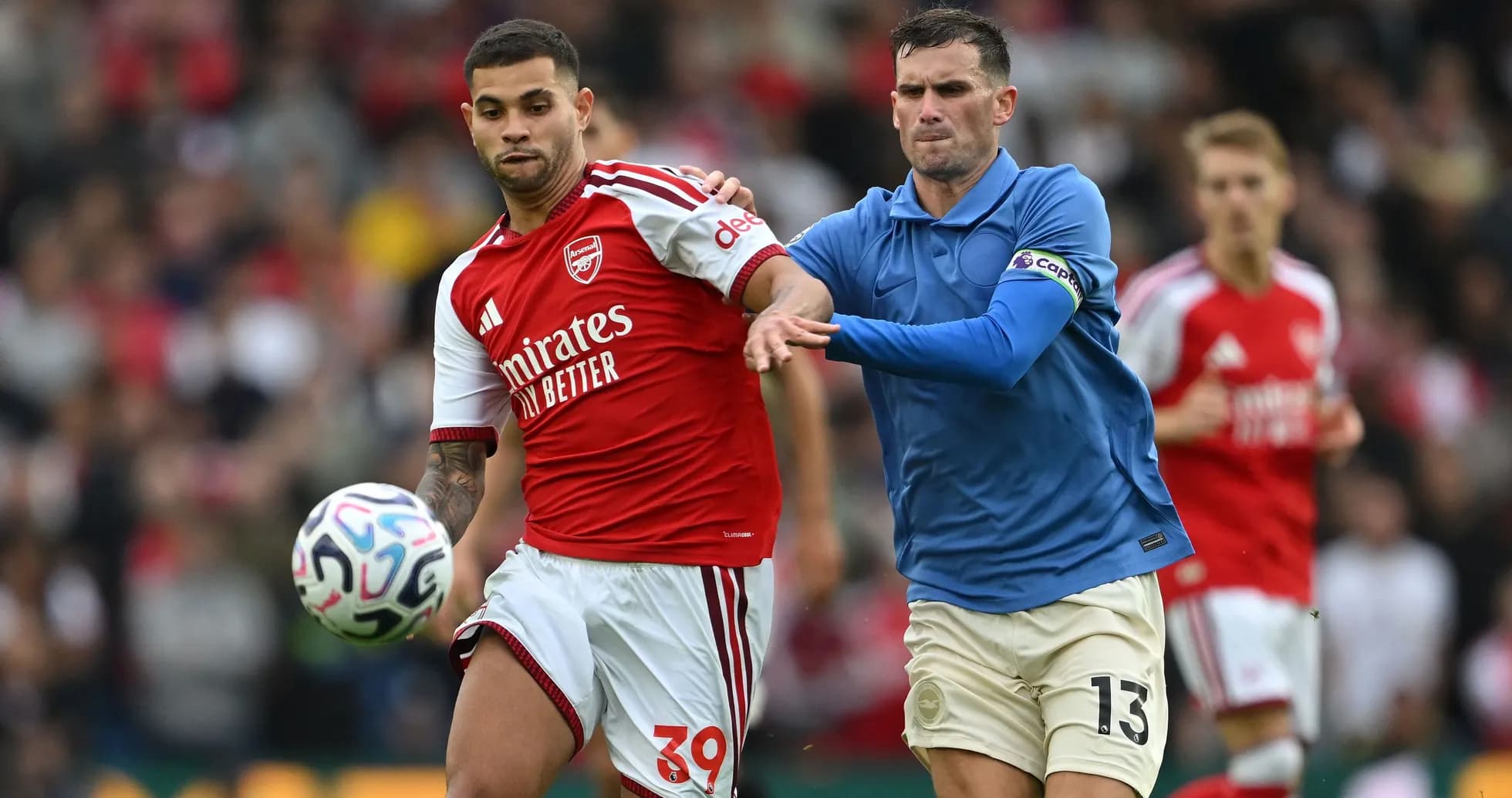 Player from Arsenal dribbling past opposing defender Player from Arsenal dribbling past opposing defender