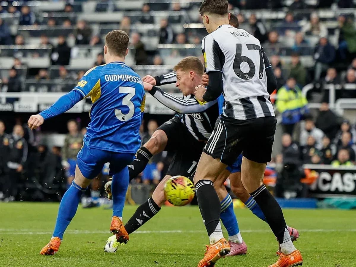 Leeds player tackling Newcastle opponent during match Leeds player tackling Newcastle opponent during match