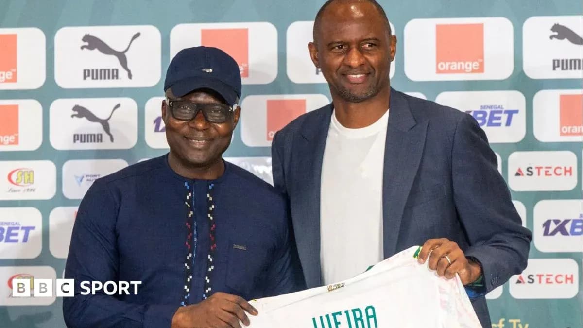 Two men holding a football shirt at a press event Two men holding a football shirt at a press event