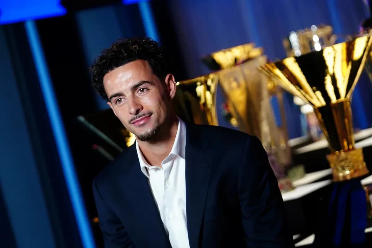 Person posing with trophies in background Person posing with trophies in background