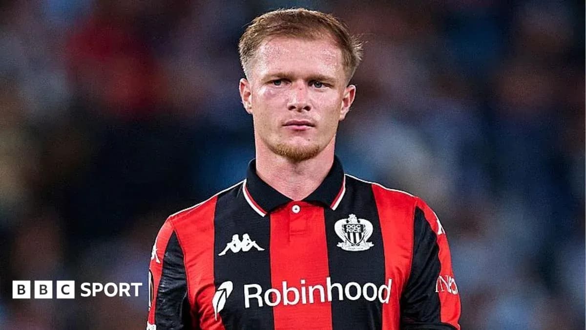 Player in black and red jersey on the field Player in black and red jersey on the field