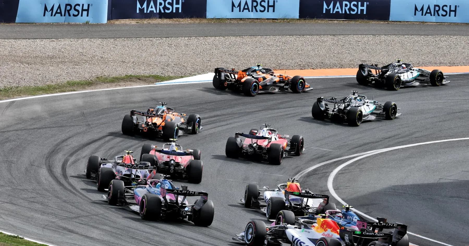 Multiple Formula 1 cars racing around a bend Multiple Formula 1 cars racing around a bend