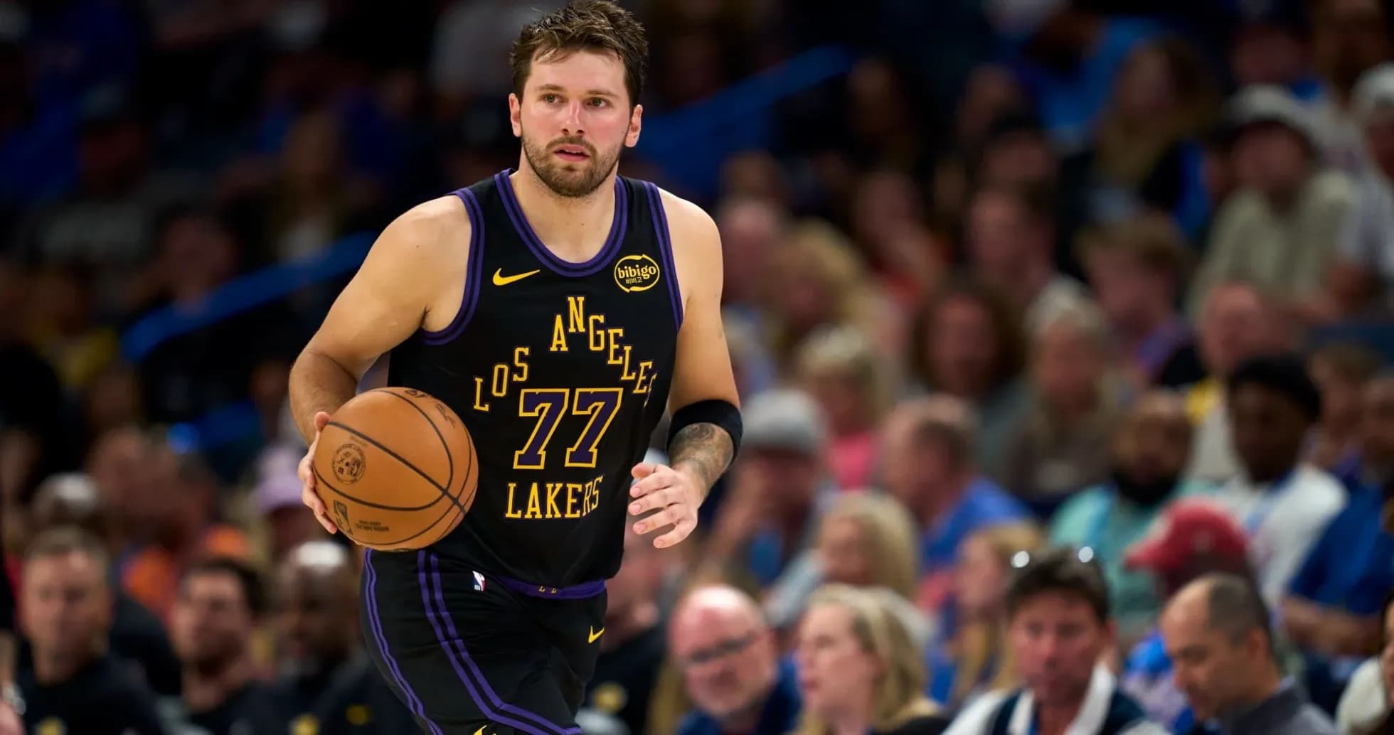 Player dribbling basketball during game with crowd Player dribbling basketball during game with crowd