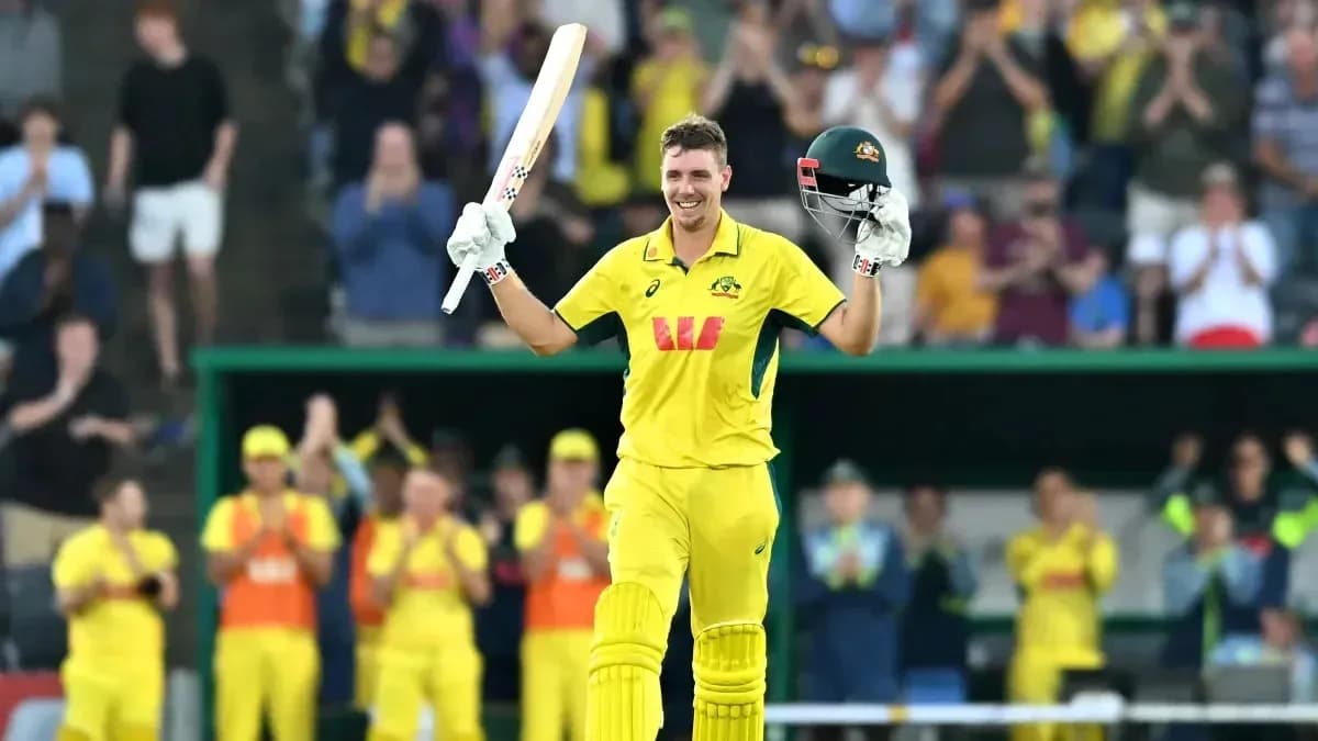 Cricketer celebrating century with bat raised Cricketer celebrating century with bat raised