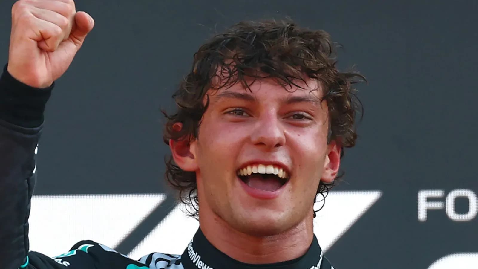 Driver celebrating with raised fist on podium Driver celebrating with raised fist on podium