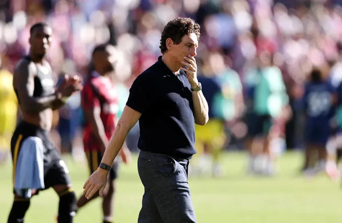 Coach walking on pitch after match conclusion Coach walking on pitch after match conclusion