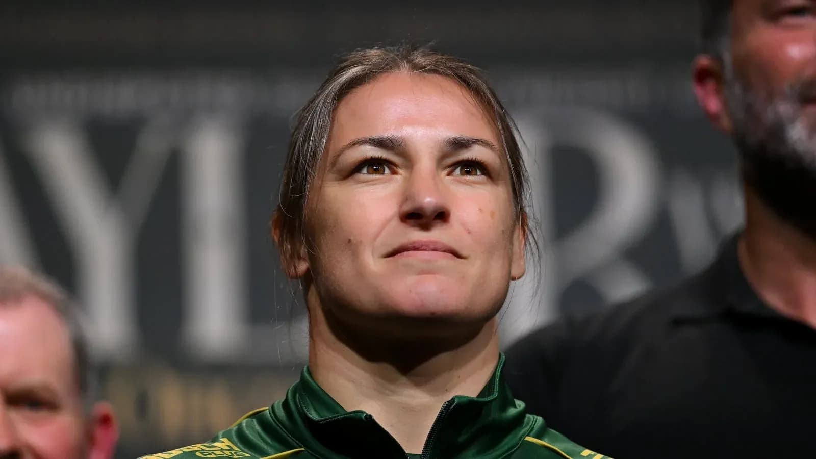 Athlete at weigh-in event wearing green jacket Athlete at weigh-in event wearing green jacket