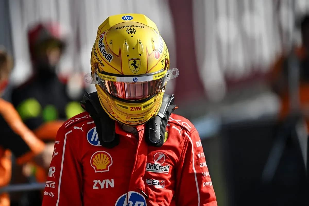 Driver wearing helmet and racing suit in paddock Driver wearing helmet and racing suit in paddock