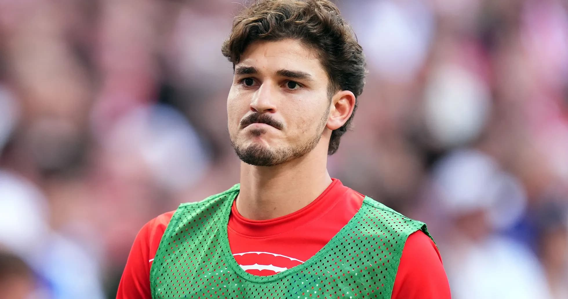 Player in training vest on sidelines during match Player in training vest on sidelines during match