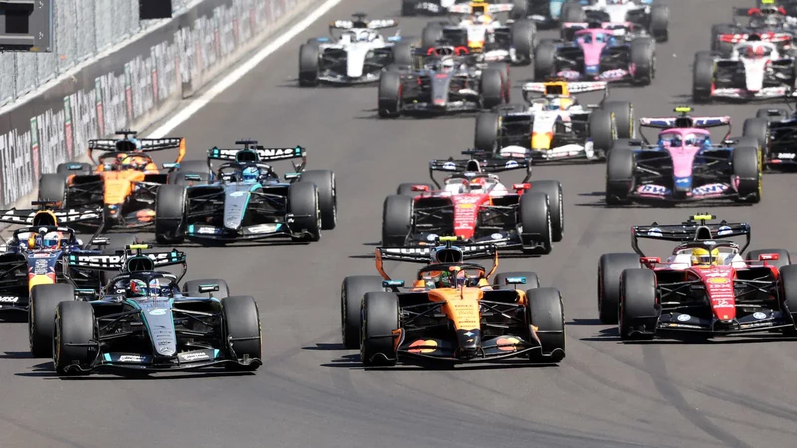 Formula 1 cars racing closely during a competition Formula 1 cars racing closely during a competition