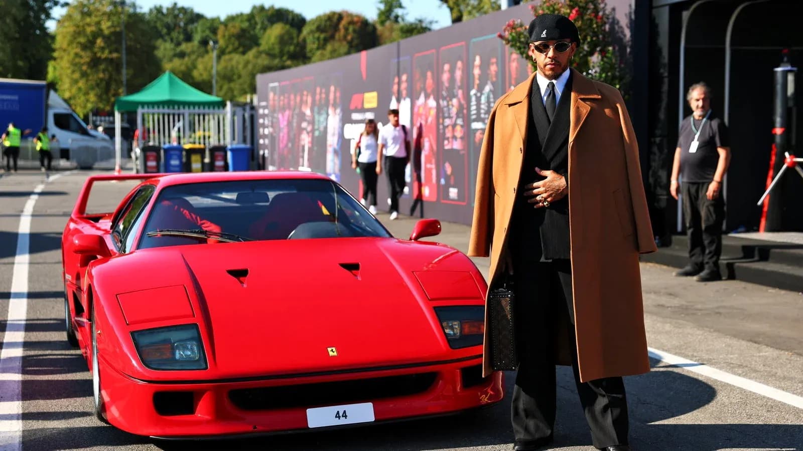 Person in stylish outfit beside red Ferrari F40 Person in stylish outfit beside red Ferrari F40